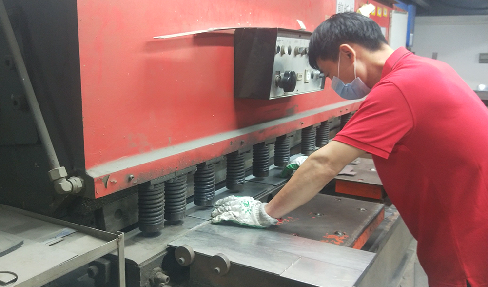 Factory worker forming stainless steel sheet for equipment production